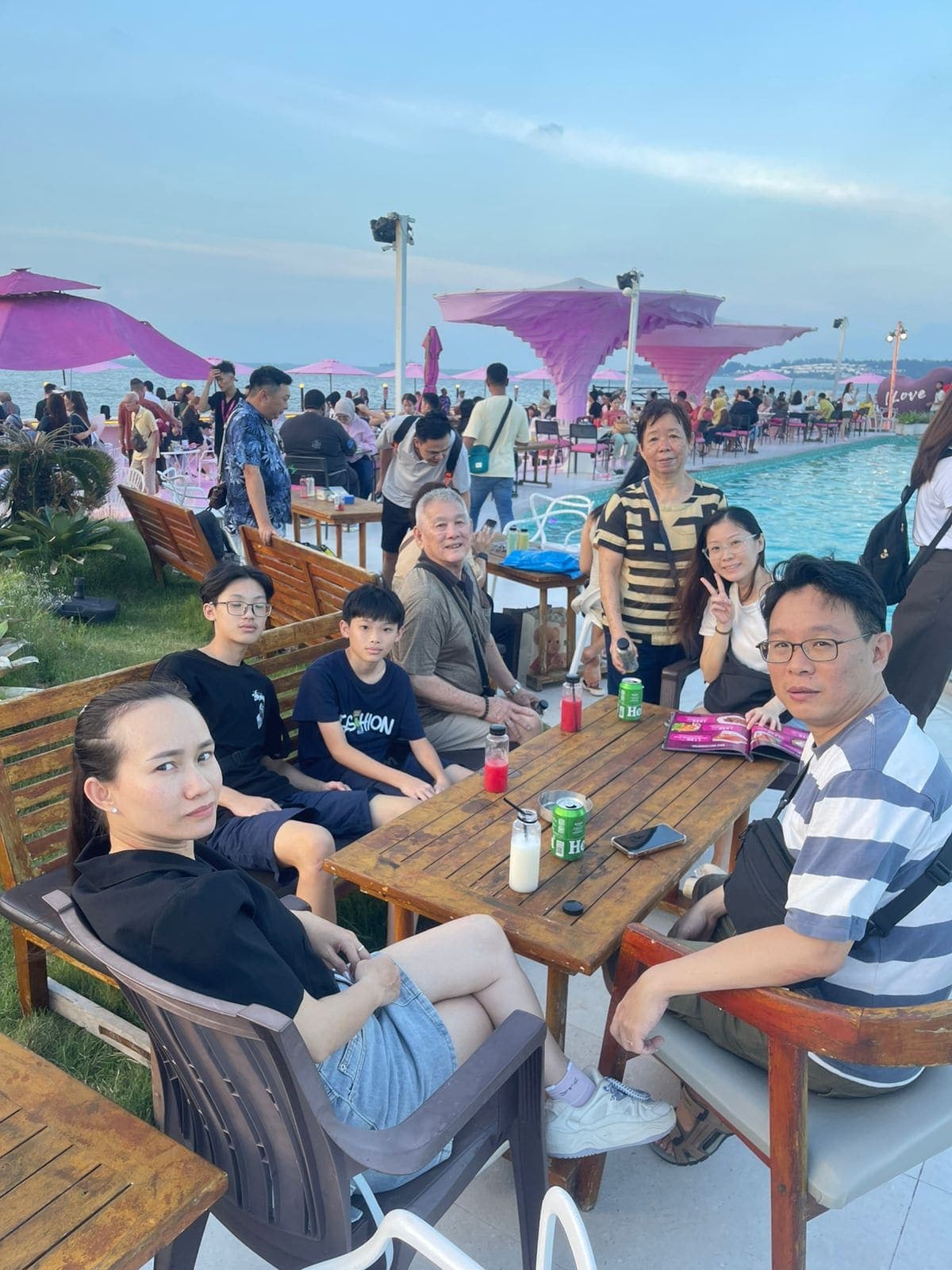 A group relaxing at a beach club with pool and ocean view in Batam