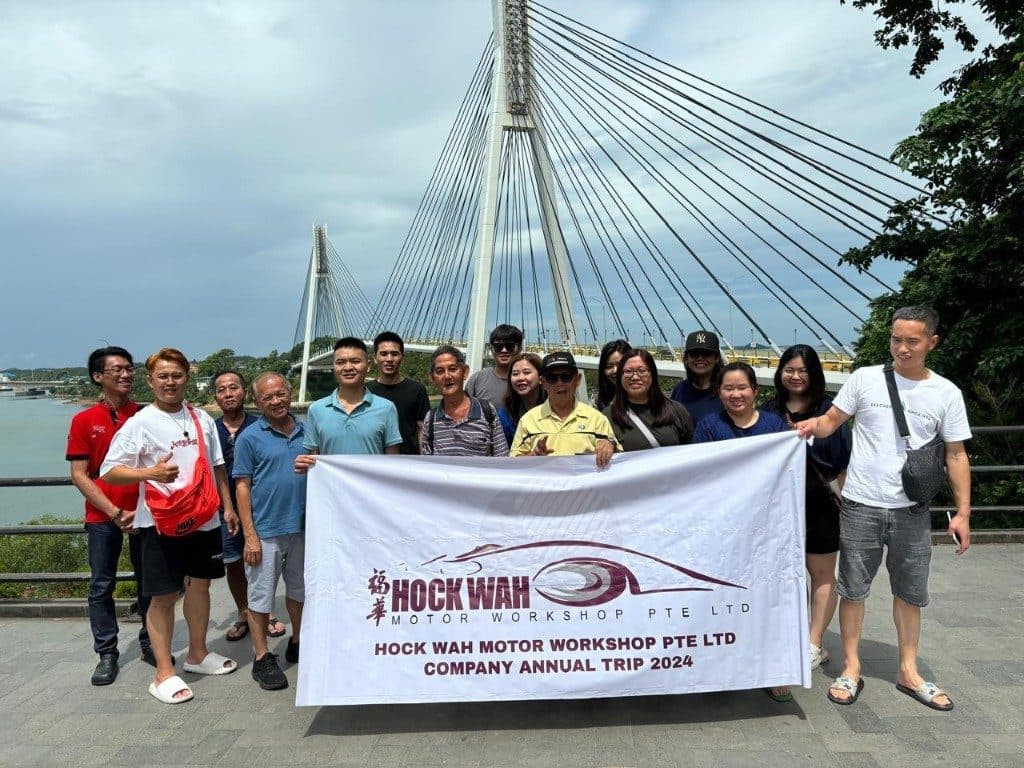 The Hock Wah Motor Workshop team with their annual trip banner at Barelang Bridge