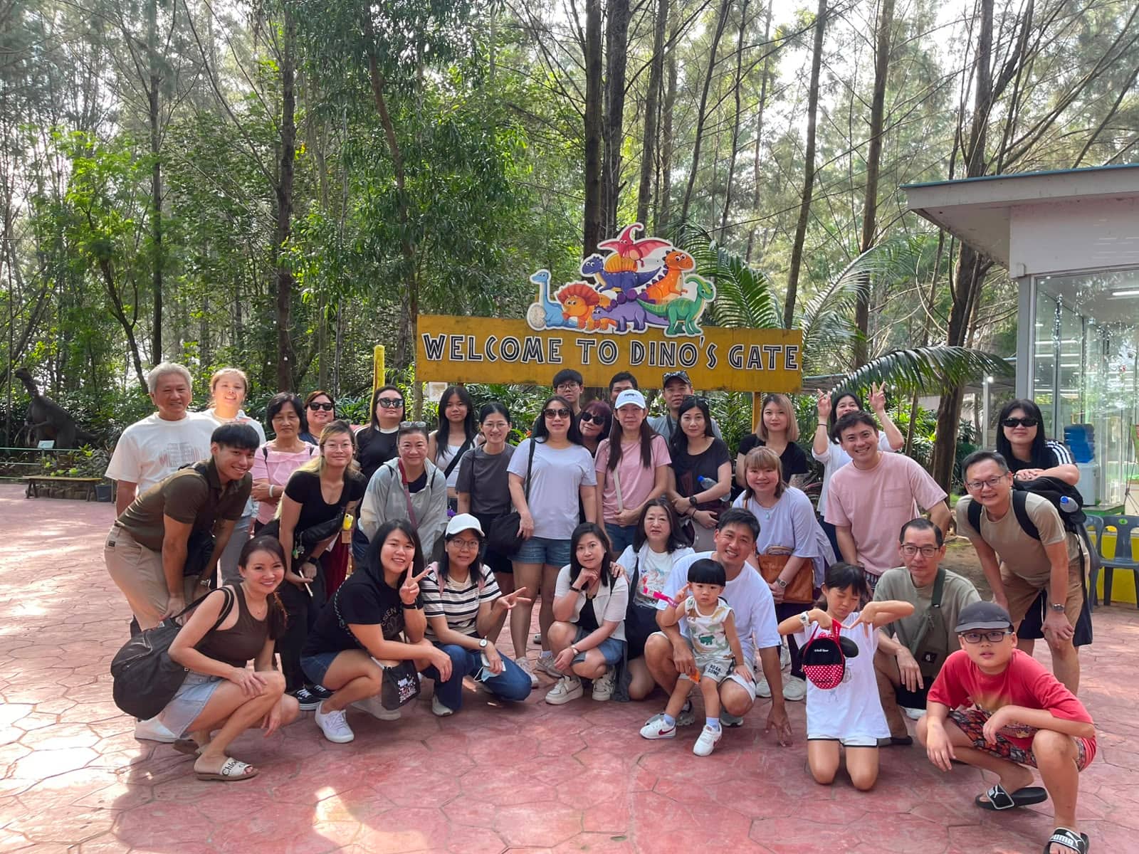 A large tour group under the Welcome to Dino's Gate sign in Batam
