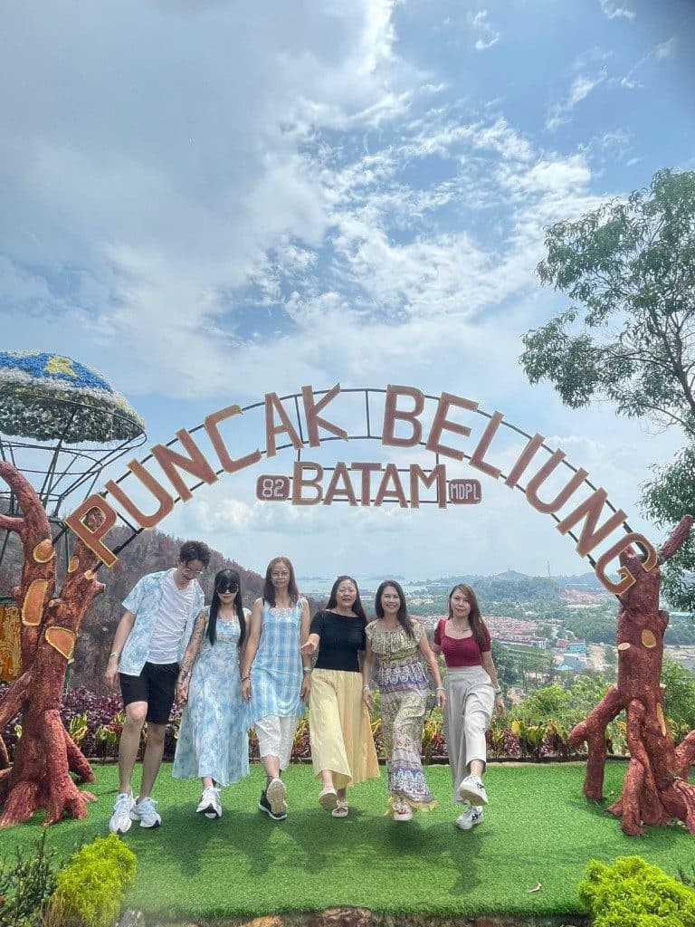 Guests under the Puncak Beliung arch on a hilltop above Batam